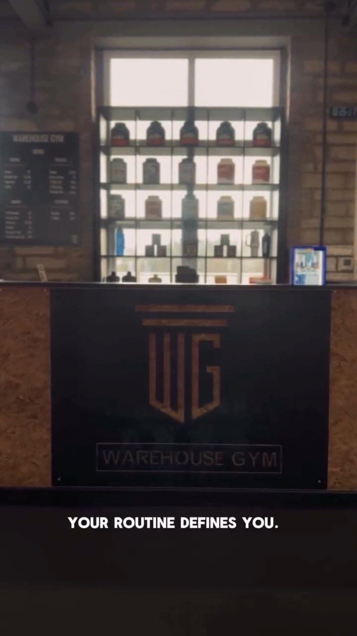 Reception at Warehouse Gym with the WG logo on the wall